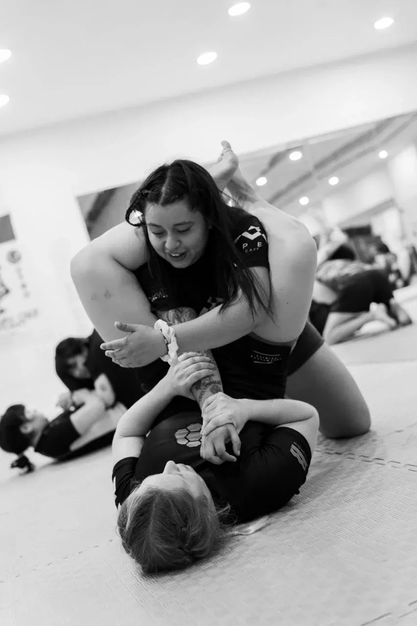 Dos alumnas de APEX entrenando, una sonríe mientras controla a su compañera