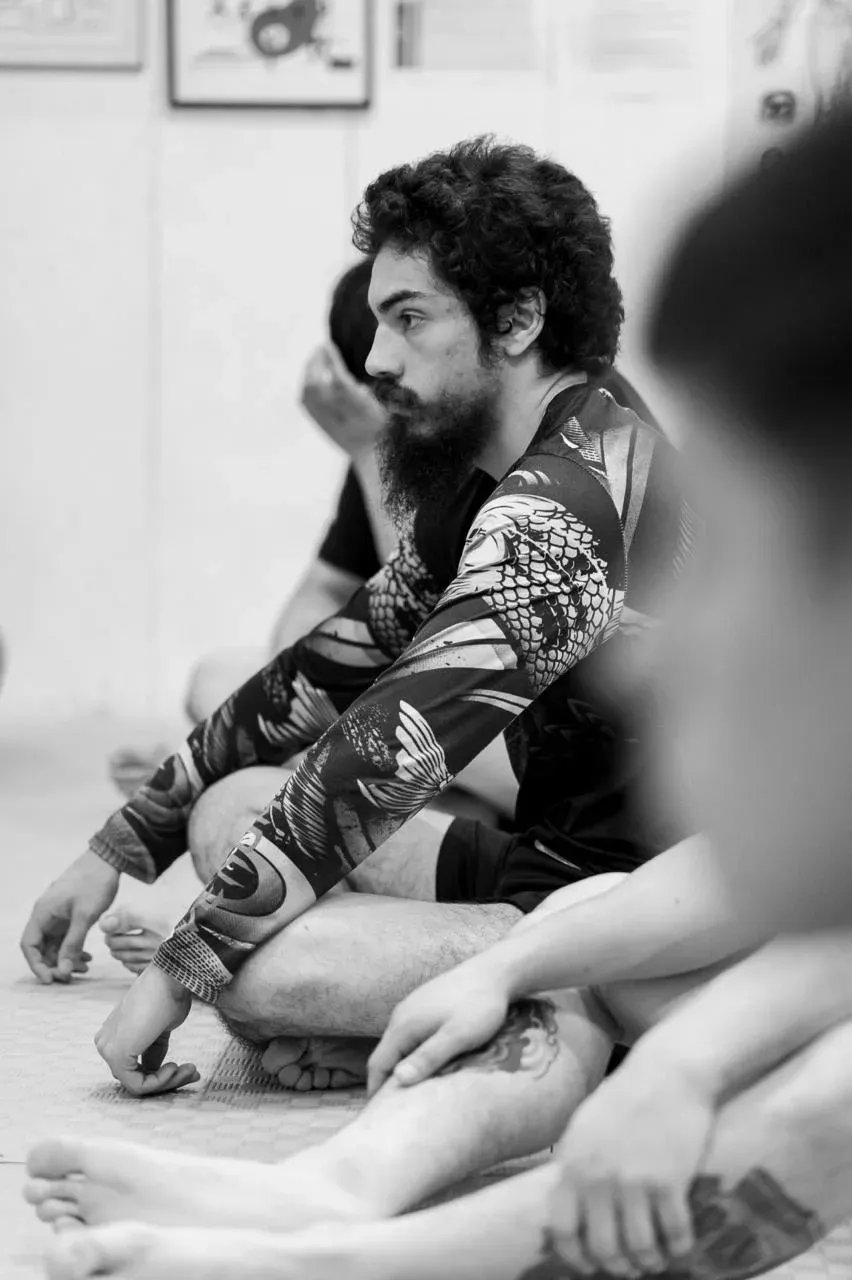 Alumno de APEX sentado en el tatami, atento a la explicación del profe